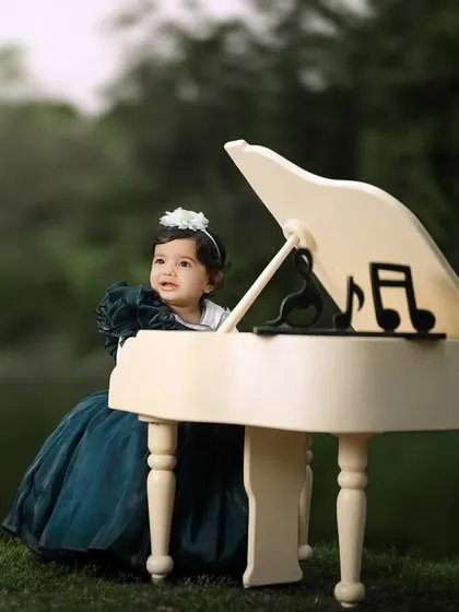 A dreamy portrait of a little girl at her piano by the lake. The soft lighting and serene background create a beautiful, artistic image.