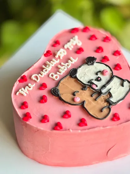 For the Duddu to your Bubbu. This cute pink heart-shaped cake features a hand-piped illustration of the famous bears, surrounded by tiny red hearts.