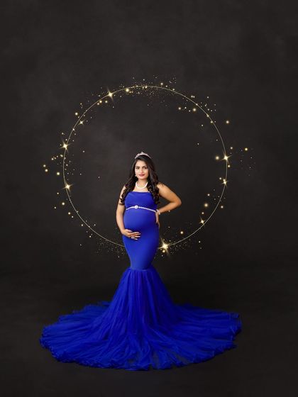 A regal portrait in royal blue. The sparkling ring of light and elegant tiara add a celestial, queenly touch to this stunning maternity photo.