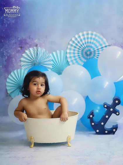 A simple and sweet bathtub session with a blue nautical theme. The anchor prop and blue balloons create a fun, sky-and-sea vibe for this little splasher.