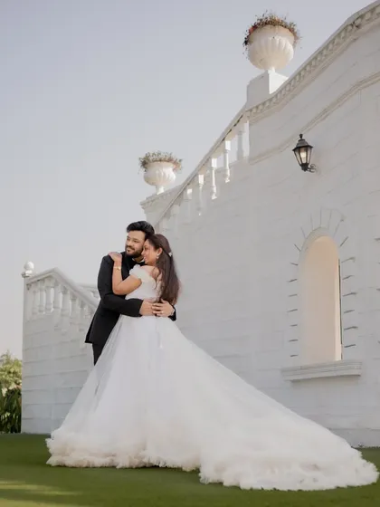 The couple shares a quiet moment together in front of a beautiful white building, a perfect shot from their elegant pre-wedding session.