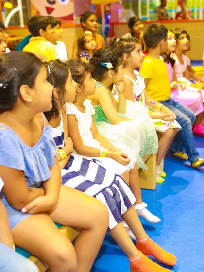 An audience of excited children watching a magic show. Entertainment is a key part of our premium party packages.