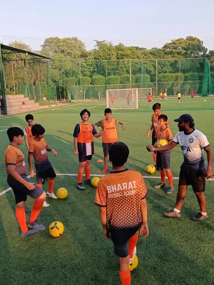 A coach provides feedback and encouragement during a drill. We believe in hands on mentorship to guide our players.