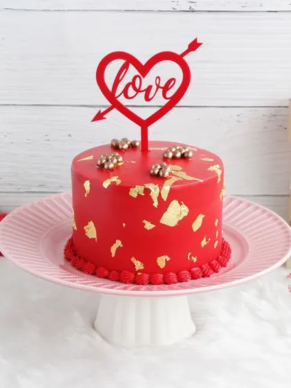 A striking red Valentine's cake decorated with gold leaf for a touch of luxury and romance.