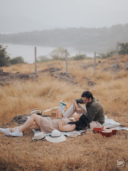 A tender moment during a lakeside picnic. The gentle interaction and beautiful natural surroundings create a soft and romantic atmosphere for this pre-wedding portrait in Lonavala.