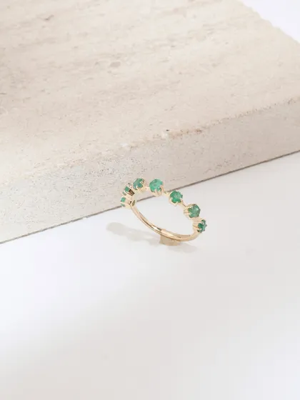 The delicate Petit Emerald ring, perfect for stacking or wearing on its own for a subtle touch of color.