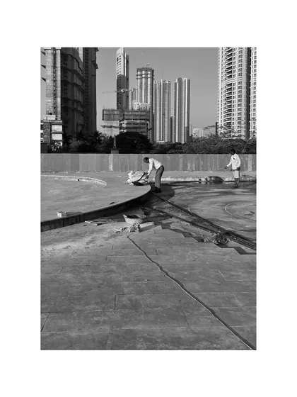 Our team at work on a vast podium, with the city skyline as our backdrop. This image captures the scale of our commercial landscape projects and our hands-on involvement in every stage of the civil work and construction.