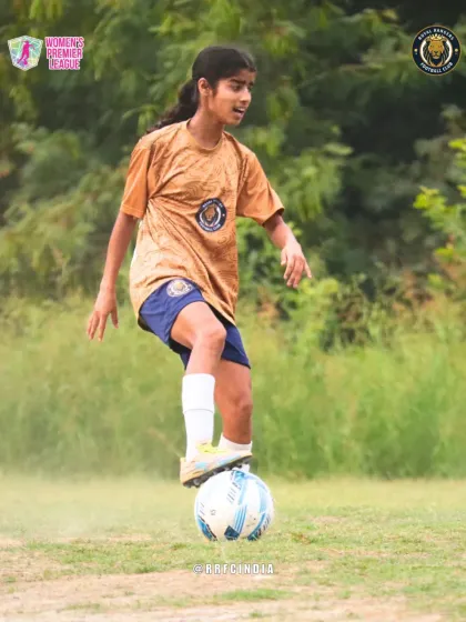 A portrait of focus. One of our players stands with her foot on the ball, calm and ready for the next play.