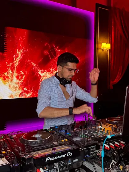 In my element, mixing tracks with a fiery visual backdrop. This is a close up of my Pioneer DJ setup during a high energy set.