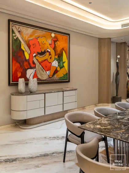 Art is central to our design philosophy. Here, a large, vibrant Ganesha painting becomes the focal point of the dining area, beautifully complementing the modern credenza and elegant dining set.