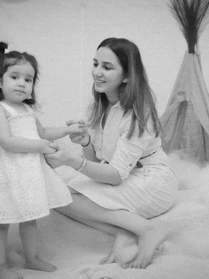 A mother and daughter holding hands, captured in a grainy, film-like black and white that adds a touch of nostalgia.