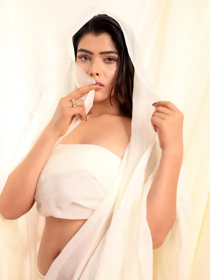An ethereal portrait of a model draped in white fabric, looking mysteriously at the camera. This shot focuses on simplicity and emotion.