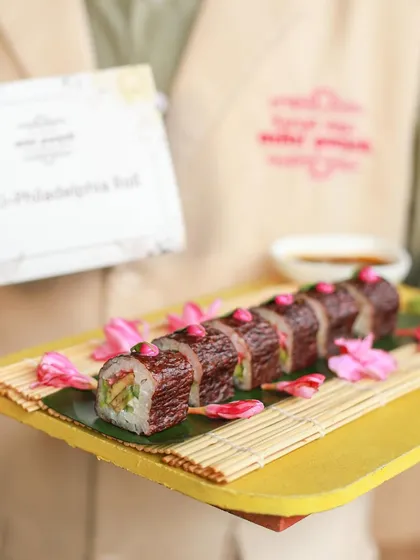 A beautifully presented Maki-Philadelphia Roll, showcasing our skill in crafting exquisite sushi. The presentation with edible flowers adds a touch of elegance.