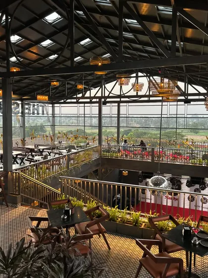 For 'The Soda Factory' pub in Mandya, we designed a multi-level green experience. This view shows how we integrated planters and greenery throughout the industrial-style space, enhancing the ambiance and offering patrons a view of the surrounding landscape.