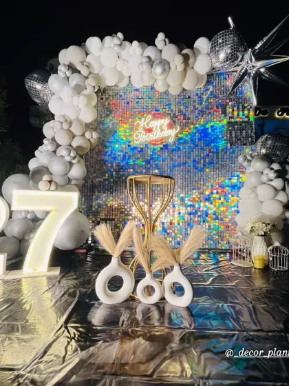 Details matter. This close-up highlights the modern white vases with pampas grass, the golden table, and the star-shaped foil balloons that completed this stylish and glamorous 27th birthday decor.