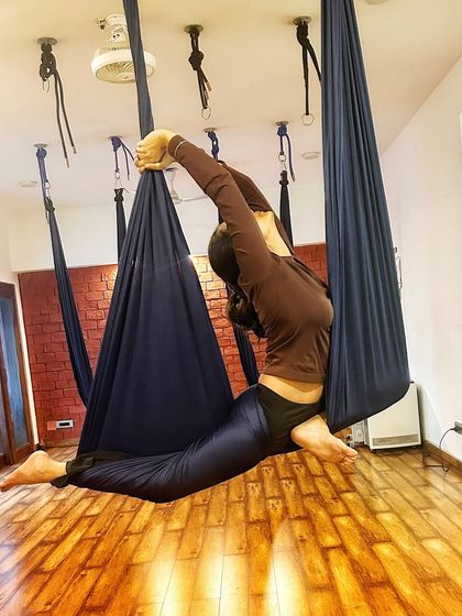 Another angle of the aerial backbend, highlighting the grace and strength involved. This pose helps open the heart and shoulders.
