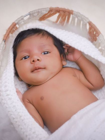 This little one is nestled in a soft, woven basket. We use simple, natural props to keep the focus on your baby's adorable features.
