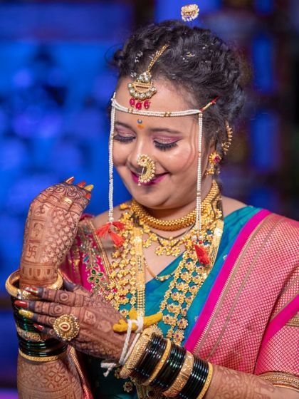 A beautiful Maharashtrian bride, her smile as bright as her jewelry. Her traditional mehendi design perfectly complements her entire look.