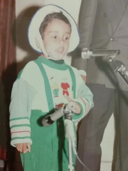This is me as a child, already on stage. My grandfather always believed in my potential. This journey of public speaking started long ago and has defined who I am today.