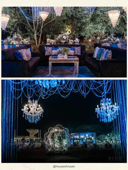 A wide shot of the Sangeet lounge area, where crystal chandeliers hang under a canopy of blue light strings, creating a luxurious and celestial atmosphere.