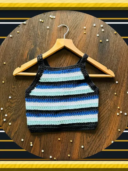 This is my striped halter neck crop top, laid flat to show the clean lines and stitch work. It’s a great piece for summer, handmade with soft cotton yarn for comfort.