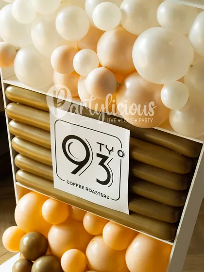 A close-up of our branded coffee cup sculpture. The logo is prominently displayed, and the different layers of balloons cleverly mimic the look of a layered coffee drink.