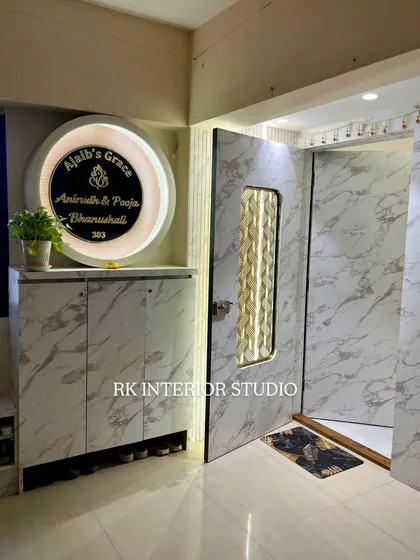 This elegant entrance features a marble-laminate finish on the door and shoe cabinet. The large, circular backlit nameplate adds a personalized and luxurious touch.