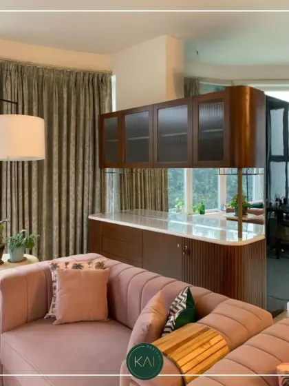 A partial view of a living room featuring a custom-made pink channel-tufted sofa. This piece adds a soft, feminine touch and a pop of color, demonstrating our ability to create furniture that reflects personal style.