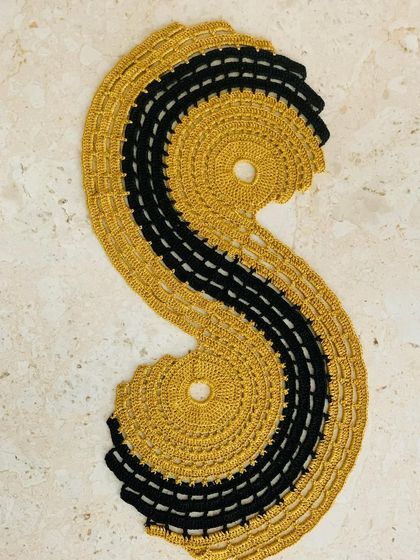The spiral table runner in a classic and elegant gold and black combination. It's a statement piece that adds a touch of luxury to your table setting.