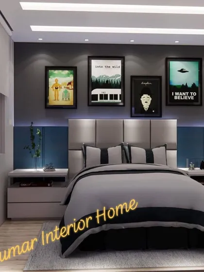A stylish bedroom with a cool-toned color palette of grey and blue. The headboard is flanked by modern nightstands, and the wall features a collection of pop culture art prints.