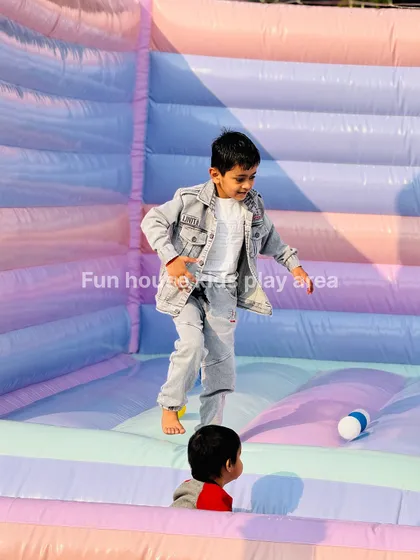 A young boy mid-bounce inside our pastel inflatable, showing the fun and freedom of our safe and spacious castles.