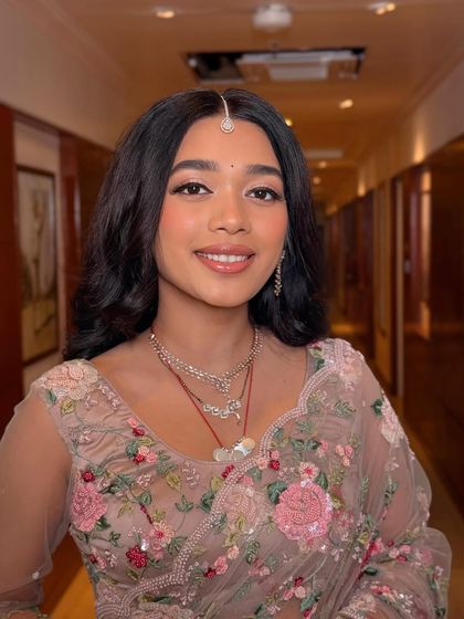 A close-up of the bride's beautiful reception makeup. The look is soft and ethereal, with a focus on glowing skin and a pretty pink lip.