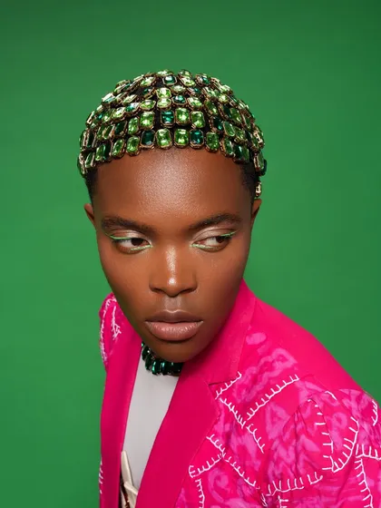 This look was all about the details. I created a custom, fully bejeweled hair cap, which took a lot of time but was completely worth it. It’s paired with a sharp, green graphic liner to tie the whole look together.