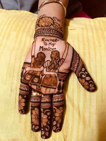 Celebrating a special bond of friendship with a custom design. This mehendi features two friends on a swing with the phrase 'Rachel to my Monica', a perfect tribute for a best friend.