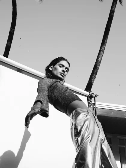 A powerful black and white shot for a Myntra FWD campaign. The low angle and stark contrast between the model, the sky, and the palm trees create a bold, high-fashion image that feels both edgy and aspirational.