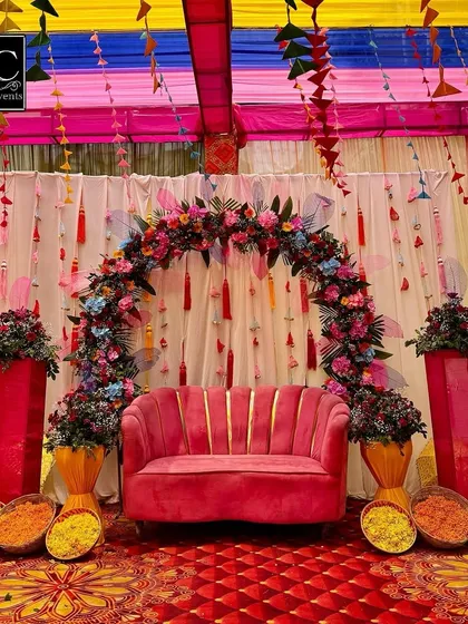 Your Mehndi should be as vibrant as you are. I created this fun and festive seating area with a plush pink sofa under a colorful floral arch, complete with hanging tassels and traditional marigold bowls for that perfect photo op.