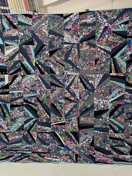 A dynamic "strip pieced" quilt, where fabric strips are sewn together improvisationally to create a modern, abstract design.