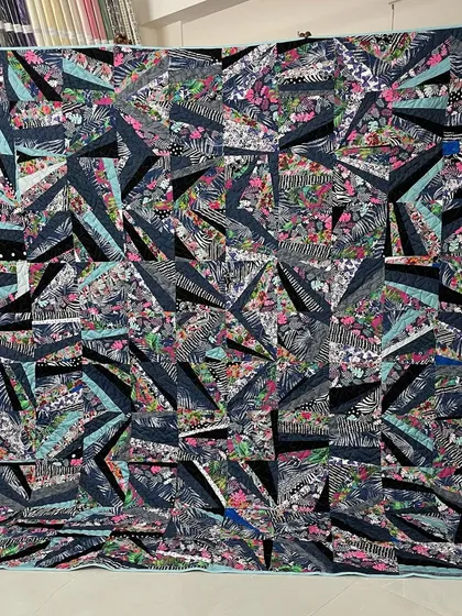 A dynamic "strip pieced" quilt, where fabric strips are sewn together improvisationally to create a modern, abstract design.