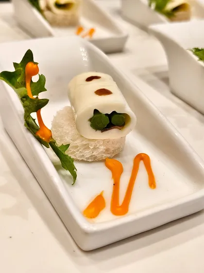 An elegant medley of textures and flavors. Soft cheese rolled with garden-fresh vegetables, resting delicately on a crisp bread base and finished with a vibrant sauce.