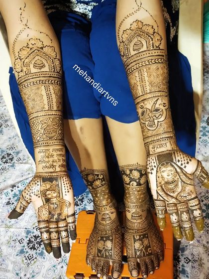 This stunning bridal mehandi includes couple portraits on the palms, personalized text, and matching intricate designs on the feet.
