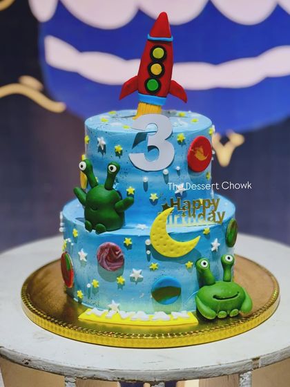 An out-of-this-world two-tier space theme cake for a 3rd birthday. I had so much fun creating the little fondant aliens, planets, and the rocket ship topper for this cosmic celebration.