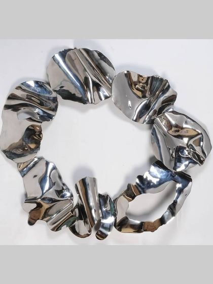 A full view of the circular loop sculpture, an early exploration into creating continuous forms from fragmented parts.