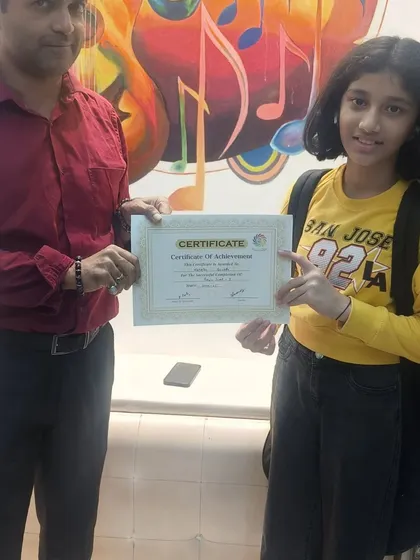 We believe in celebrating every milestone. Here, a student proudly receives her Certificate of Achievement, recognizing the hard work and progress she has made in her classes with us.