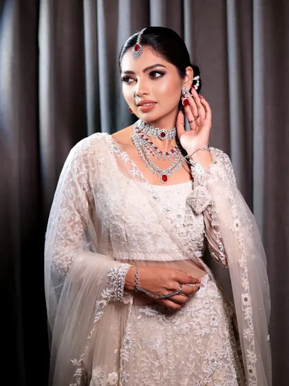 Embracing timeless elegance in a white lehenga. This look is pure sophistication, with a touch of glam from the ruby and diamond jewelry.