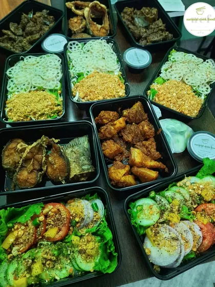 A variety of our dishes packed in containers for a custom order. You can see fried fish, salads, and curries.