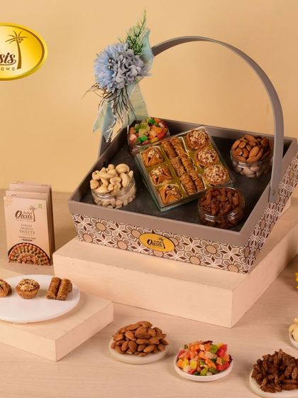 Our grey patterned basket hamper is filled with a variety of treats. It includes a box of assorted baklawa and jars of premium nuts and candied fruits.