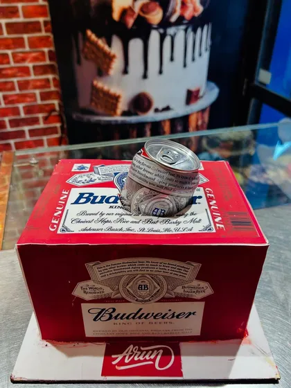 A fun and realistic Budweiser beer carton cake, complete with a crushed can on top, all made from cake and fondant.