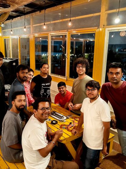 A group of friends enjoying a game of 'Secret Hitler' on a Saturday evening. The warm lighting and cozy atmosphere make it a perfect weekend hangout spot.