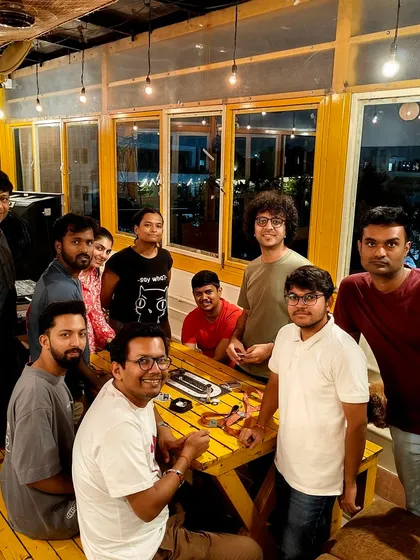 A group of friends enjoying a game of 'Secret Hitler' on a Saturday evening. The warm lighting and cozy atmosphere make it a perfect weekend hangout spot.