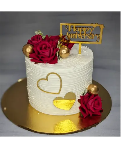 An elegant anniversary cake with fresh red roses and gold hearts. This is a fresh mango cake, perfect for celebrating a milestone with a touch of sophistication.